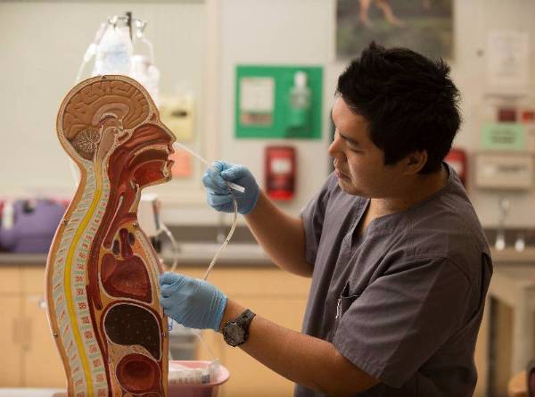 Nursing student works with a feeding tube.