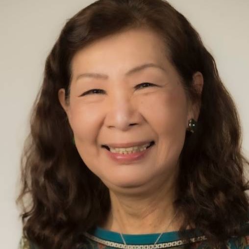 Head and shoulders photograph of an Asian woman with dark hair in her 70s